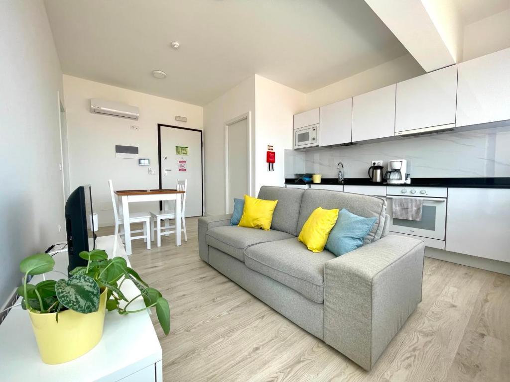 a living room with a couch and a kitchen at Apartamento T1 - MedSal Residence in Santa Maria