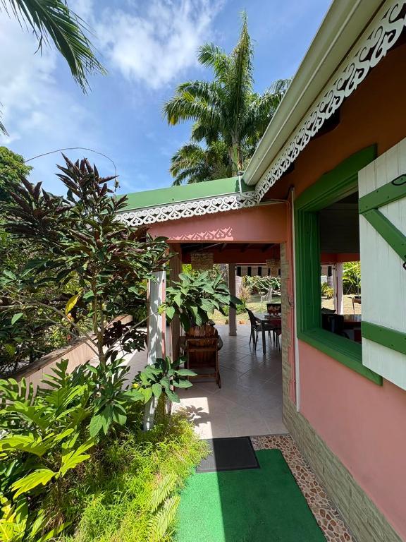 a view of a house with a garden and a patio at Gite d'arles Bungalow "La Rose" in Le Moule