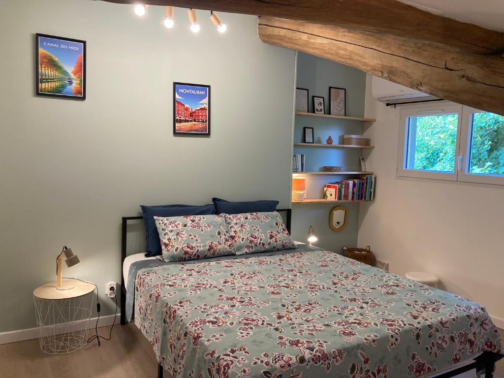 a bedroom with a bed with a green comforter at Gîte de Lafeuillade in Montech