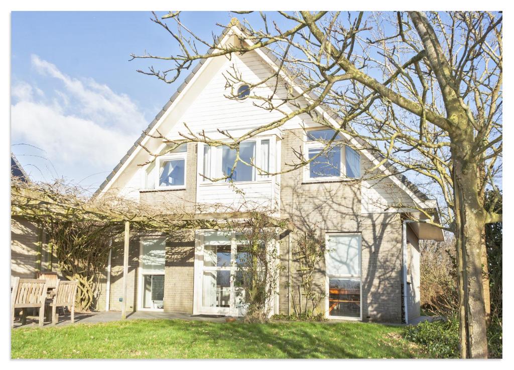 ein weißes Haus mit einem Baum im Garten in der Unterkunft Luxury Lakeside Villa in Terherne in Terherne