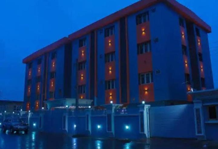 a building with a car parked in front of it at Six Diamond Hotel in Ikeja
