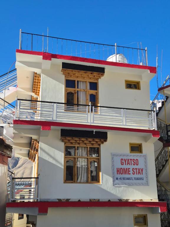 a white building with a home stay sign on it at Gyatso Home Saty in Kaza