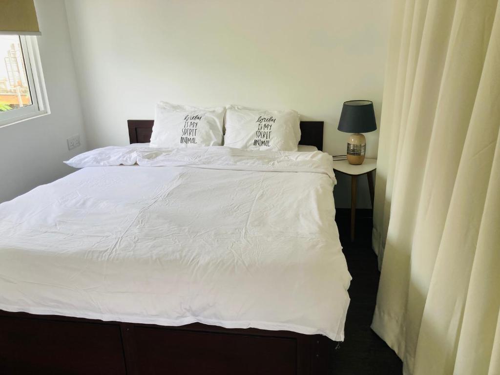 a bedroom with a bed with white sheets and pillows at My Place Sri Lanka CMB Near Airport in Katunayaka