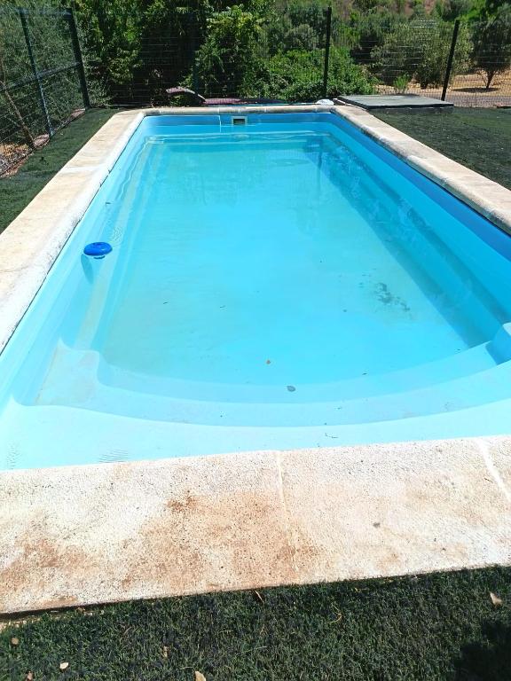 a large blue swimming pool in a yard at Casas Rurales La Lapa in El Cerro del Hierro