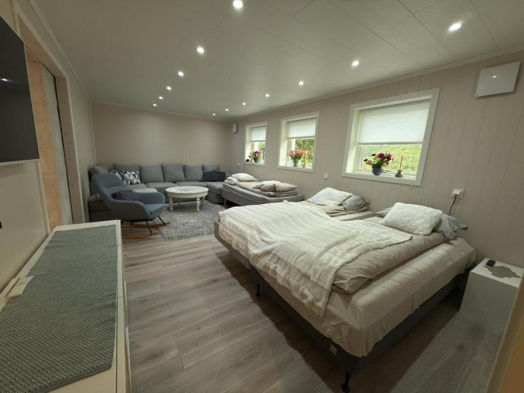 a bedroom with a bed and a living room at Flakstadveien - Sentralt, midt i Lofoten in Napp
