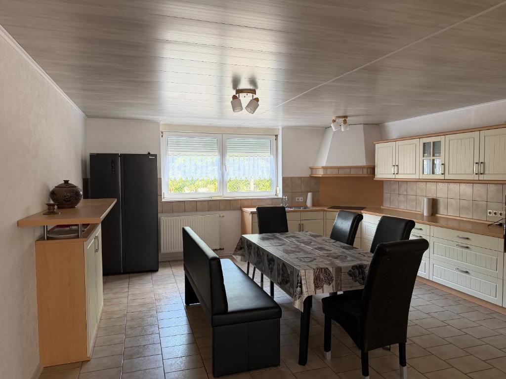 a kitchen with a table and chairs and a refrigerator at Müllers Bergnest in Deggingen