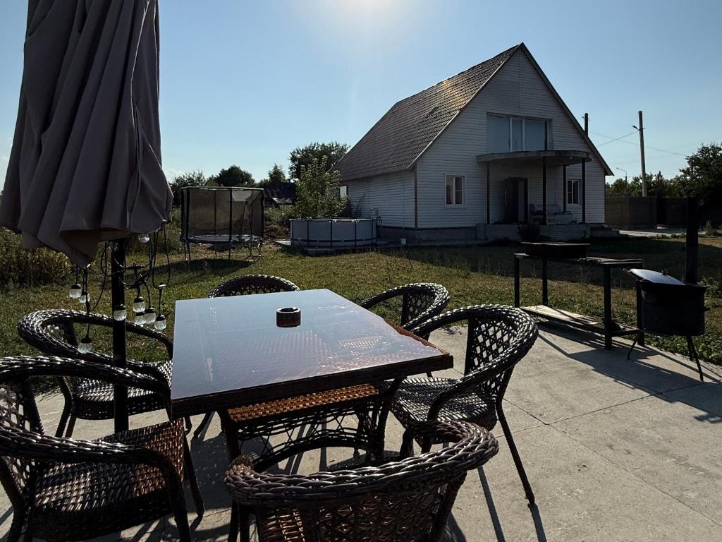 a table and chairs with a laptop on top of it at Дом с бассейном и мангальной зоной in Ustʼ-Kamenogorsk