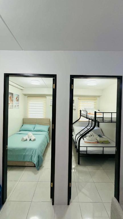a bedroom with two beds and two mirrors at 2BR Staycation in Deca Banilad by XTine City Scape in Banilad