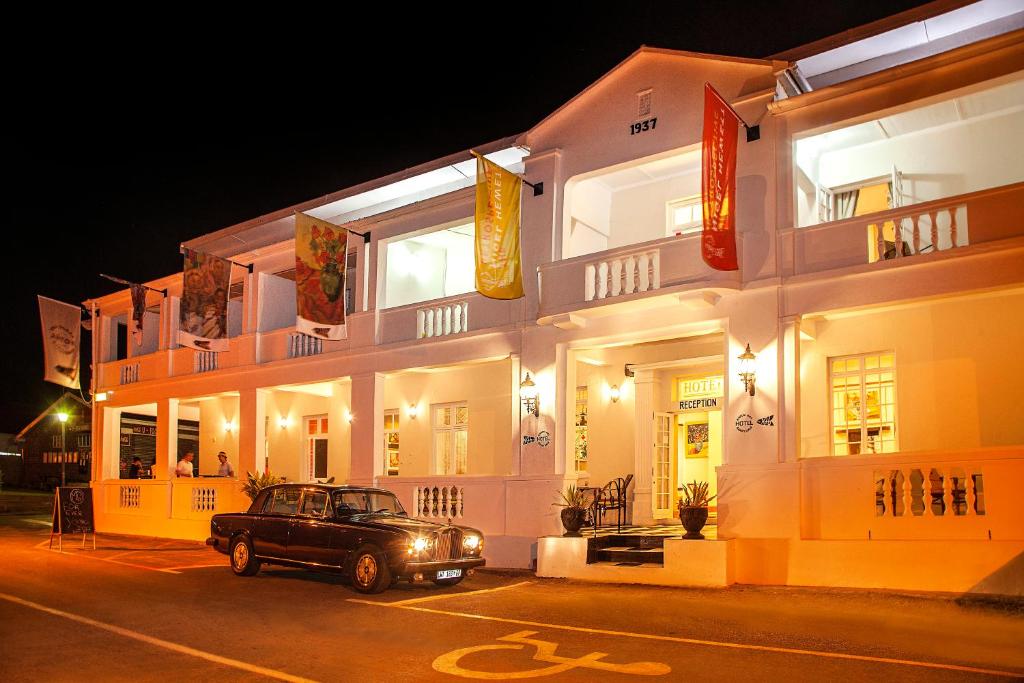 a car parked in front of a building at night at KAROO ART HOTEL 4 Star in Barrydale