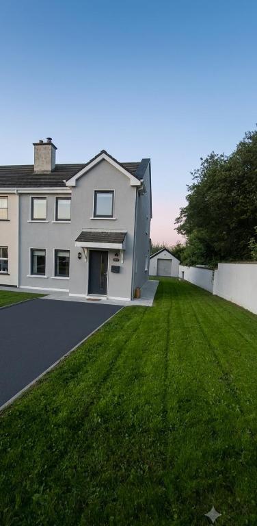 a large white house with a green lawn at Rosmore Newport in Newport