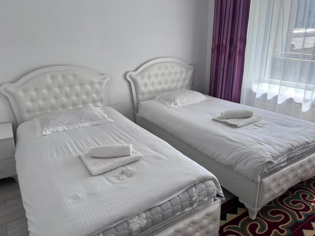 two beds sitting next to each other in a bedroom at Ala-Too Hotel in Naryn