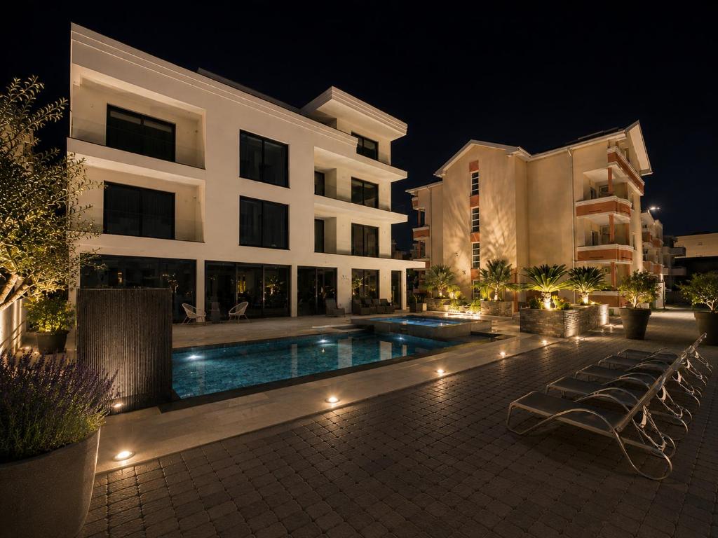 a large building with a swimming pool at night at Villa Illyria in Donji Štoj