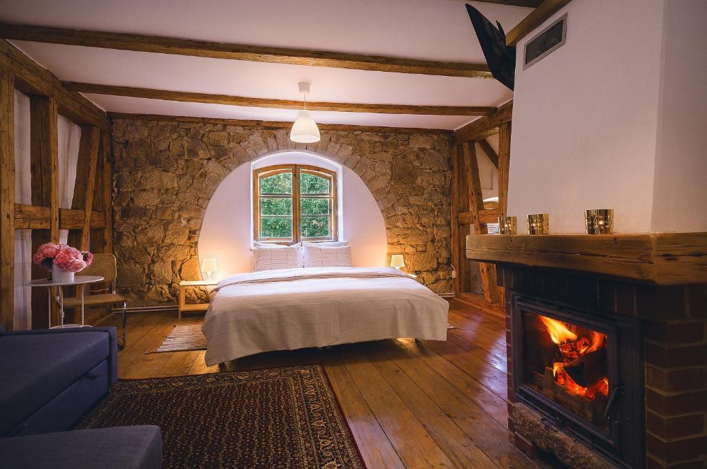 a bedroom with a bed and a fireplace at Dom Gościnny pod Zamkiem Wleń in Wleń