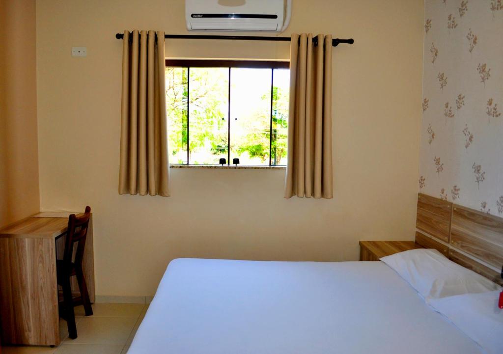 a bedroom with a bed and a window at Hotel Maranhão in Ourinhos