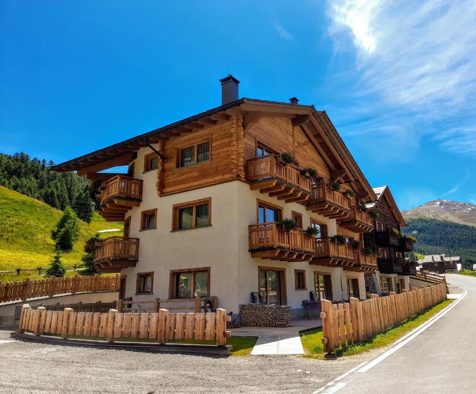 a building with wooden balconies and a fence at Hotel Li Anta Rossa - Adults Only in Livigno