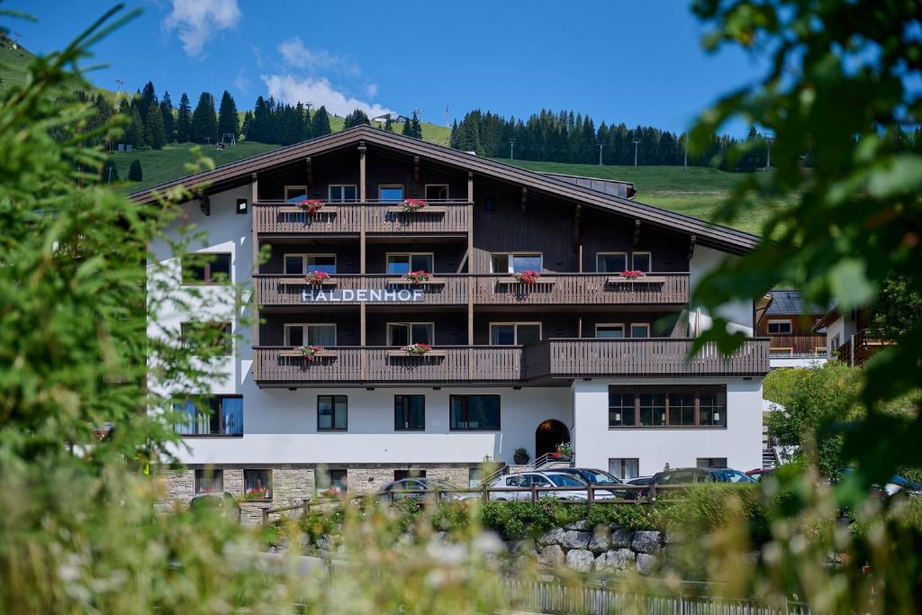 a large building with balconies on a mountain at Haldenhof in Lech am Arlberg