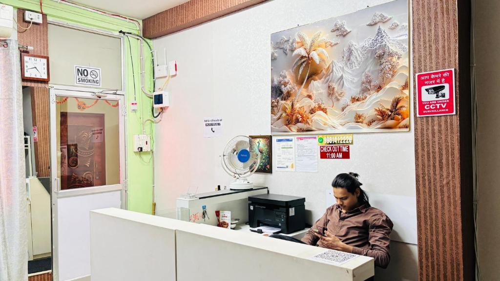 a woman sitting at a counter in a room at New royal dormitory in Raipur