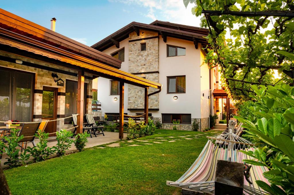 a backyard of a house with a lawn at Къща за гости Мурите in Sapareva Banya