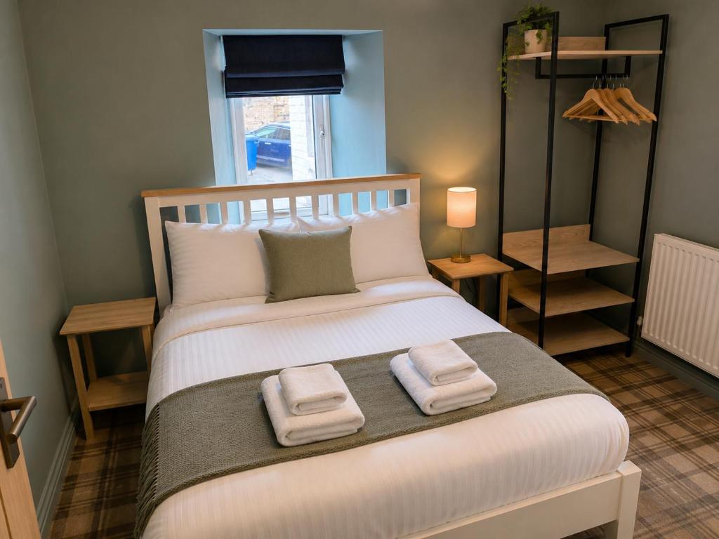 a bedroom with a large bed with two towels on it at The Ainsty in Thorp Arch