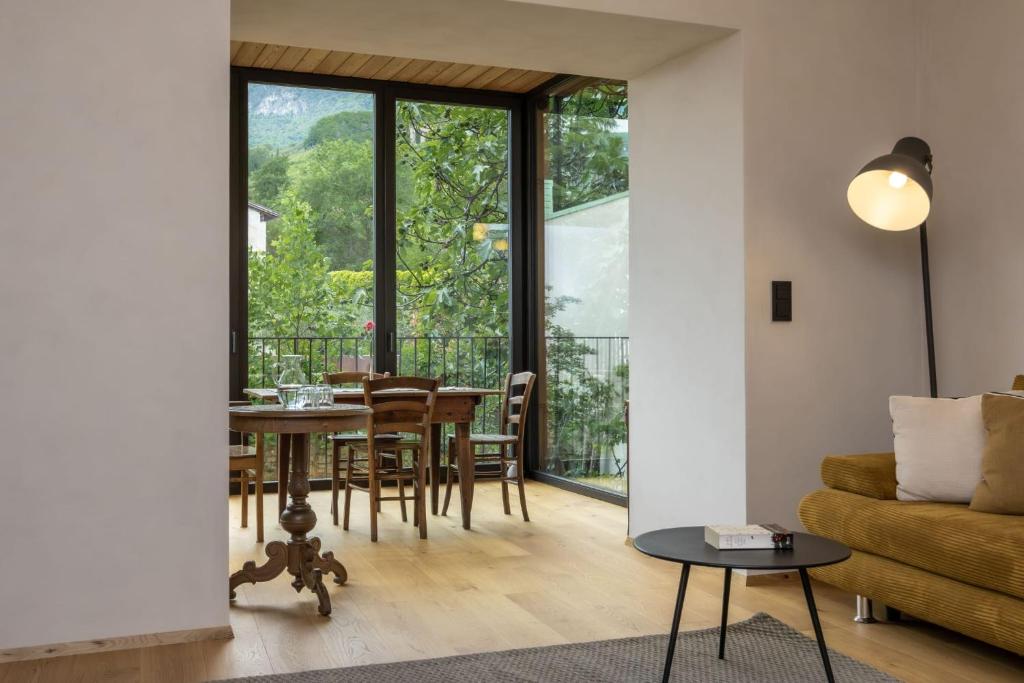 a living room with a table and a couch at Suite Lazzeri in Cortaccia