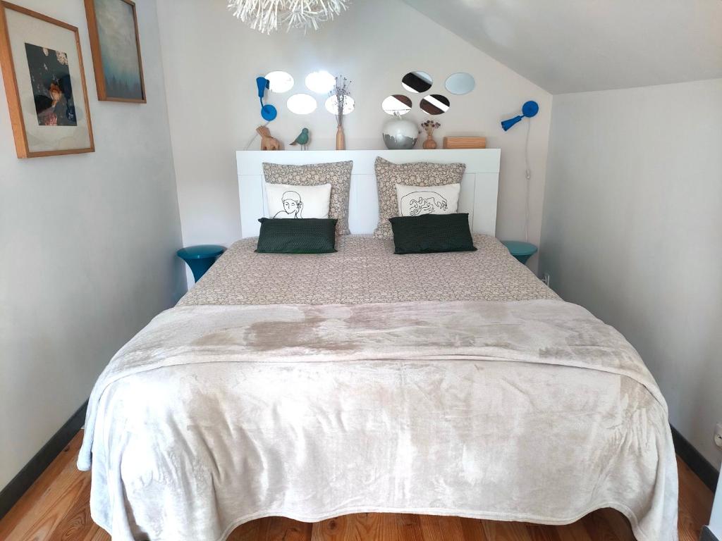 a bedroom with a large bed with a white bedspread at La Suite 27 bis, maison de charme avec terrasse, proche gare et centre in Guingamp