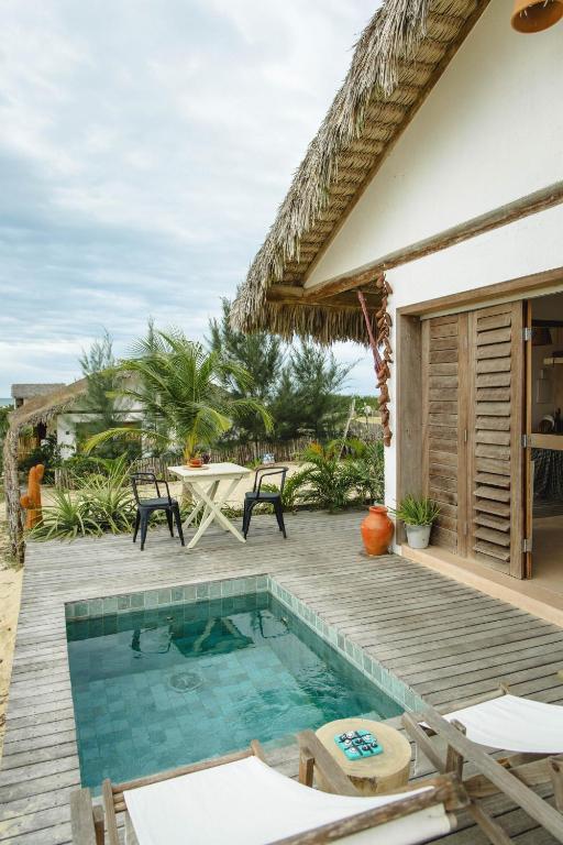 a patio with a pool and a table and chairs at Yvytu - Ohana Bungalow in Tatajuba
