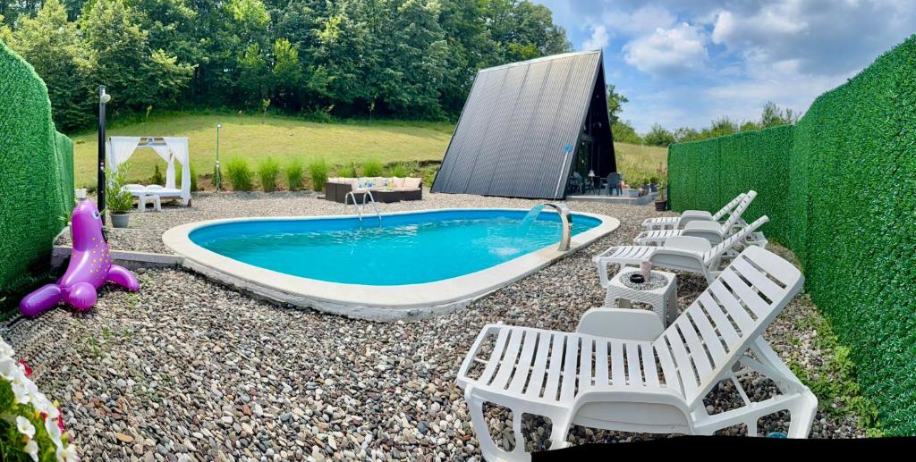 a backyard with a pool and chairs and a swimming pool at Vila Edi Tuzla in Tuzla