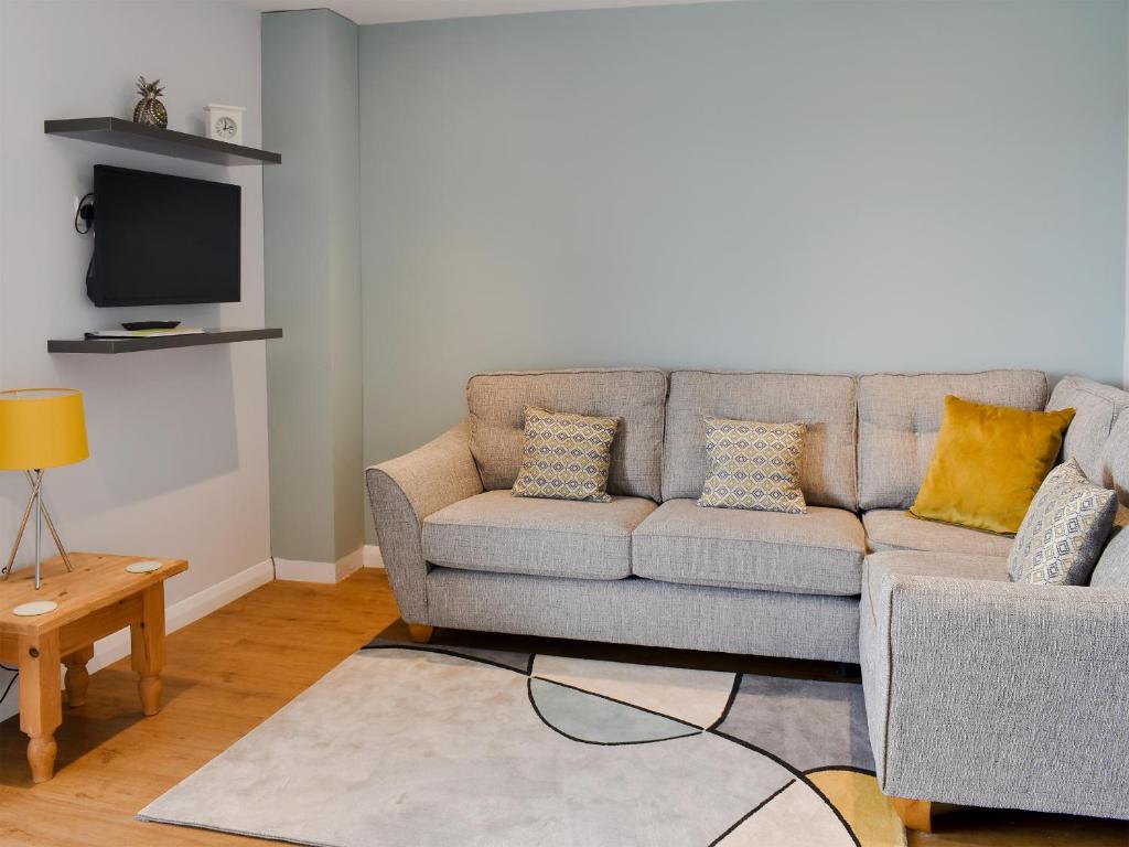 a living room with a couch and a tv at Sycamore Apartment - Uk49305 in Woolfardisworthy