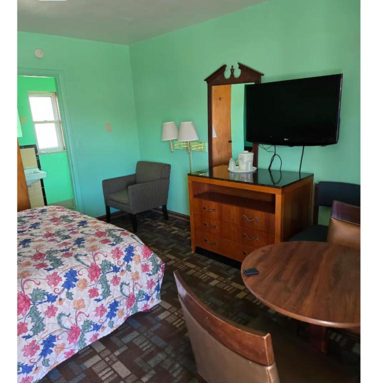 a bedroom with a bed and a flat screen tv at Capital Motel in Columbus