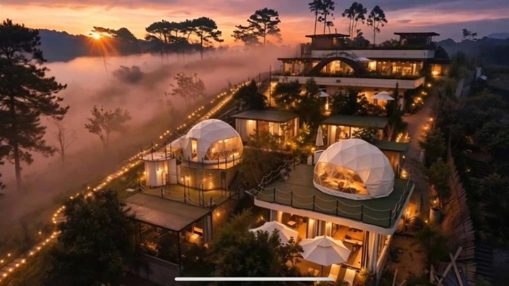a building with domes in the fog at sunset at Chanchill Glamping&cafe in Xuân Thọ