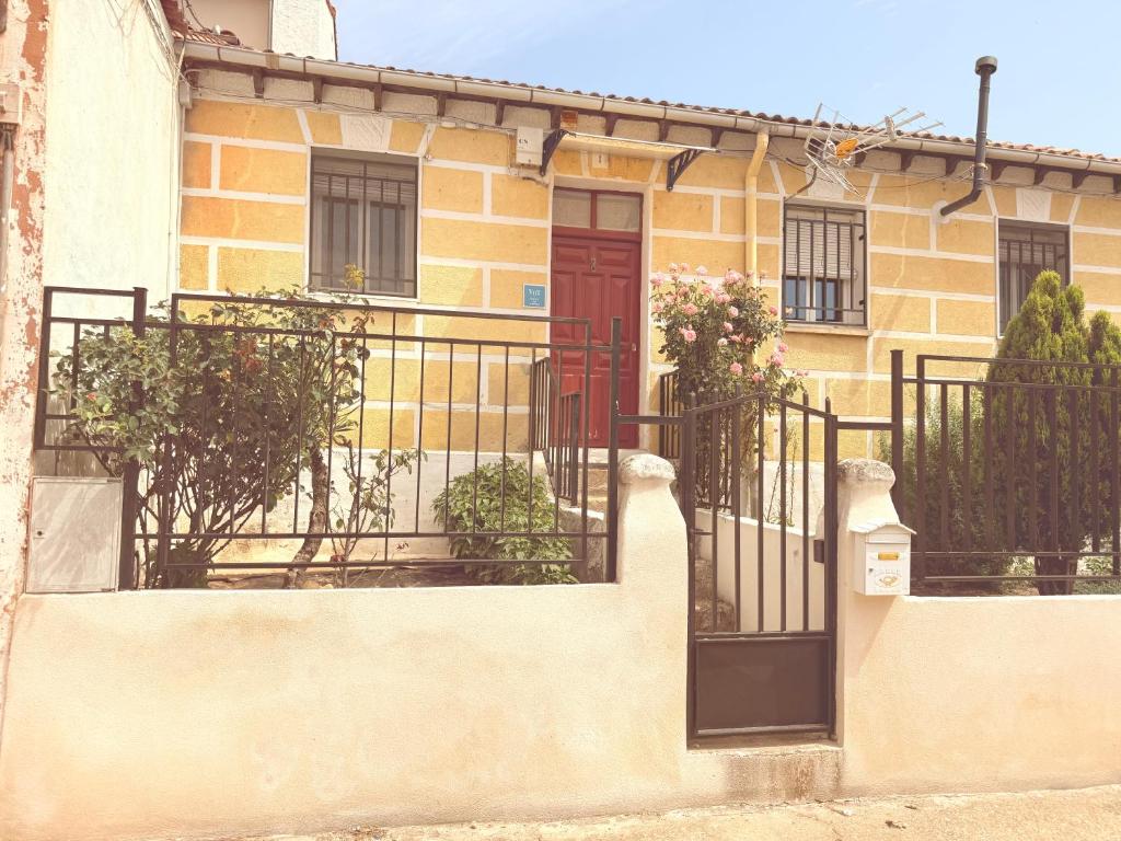 a building with a red door and a fence at San Millán 1 in Soria