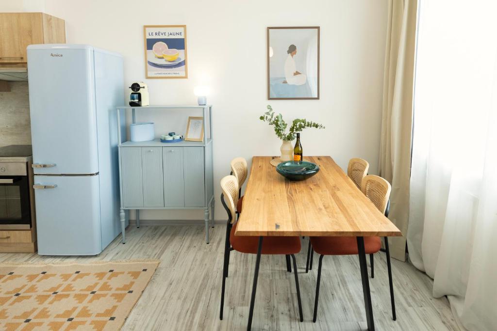 a kitchen with a wooden table and a refrigerator at Atelier Lion in Žďár nad Sázavou