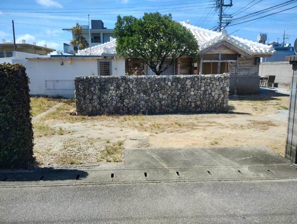 a stone retaining wall in front of a house at Unwind DAY OFF Nagamo in Yaese