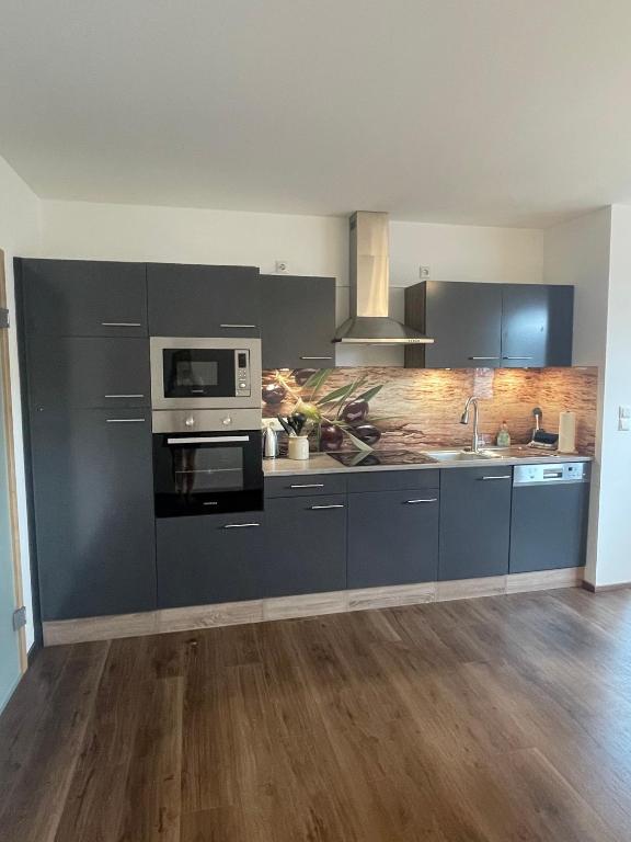 a kitchen with a stove and a microwave at Ferienwohnung Adelsried 1 in Adelsried