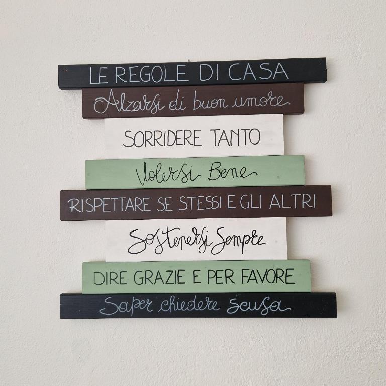 a stack of books on a wall with writing on them at Casa di Caterina in Cuneo
