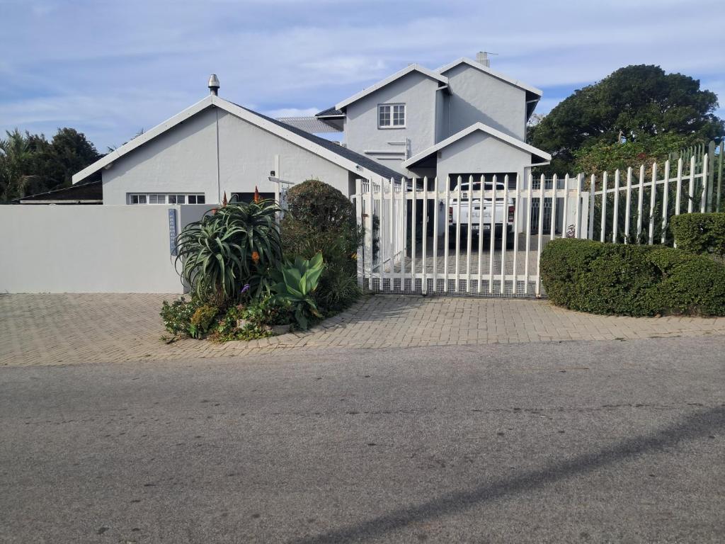 a white fence in front of a white house at Franmarel in Plettenberg Bay