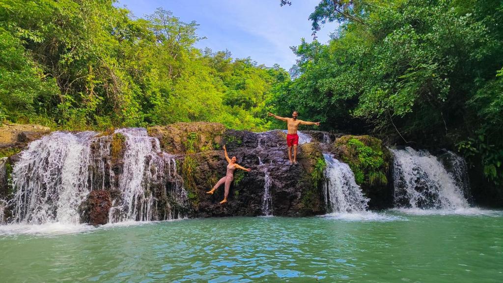 two people jumping off of a waterfall at Las Catalinas Ecológicas (El Maizal) in Antón