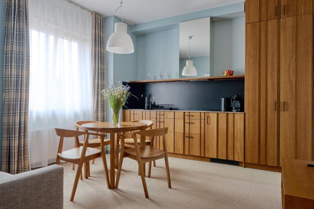 a kitchen with a table and chairs in a room at Palanga Visit Apartments and SPA in Palanga