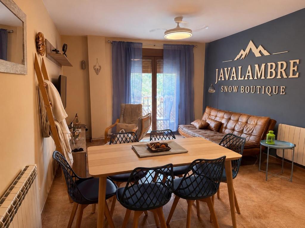 a living room with a table and chairs and a couch at Apartamento Turístico Snow Boutique in Camarena de la Sierra