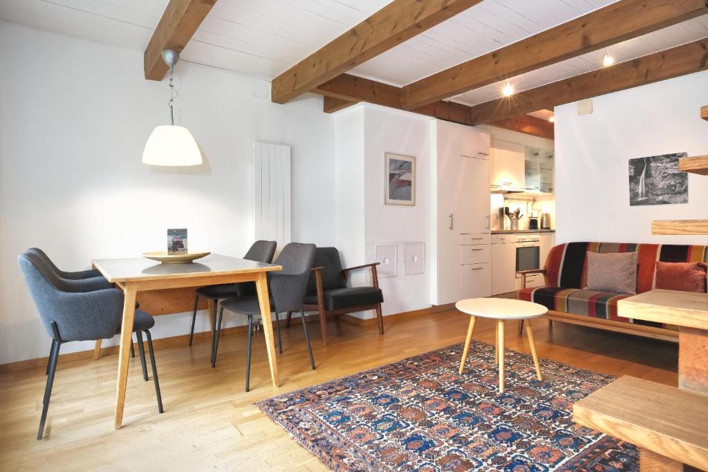 a living room with a table and chairs and a couch at Apartment Nussbaum - GRIWA RENT AG in Grindelwald