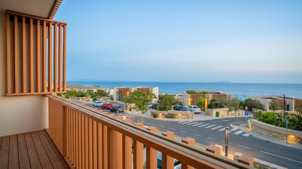a balcony with a view of a street and the ocean at Enjoy Palasa Comfy Villas in Palasë
