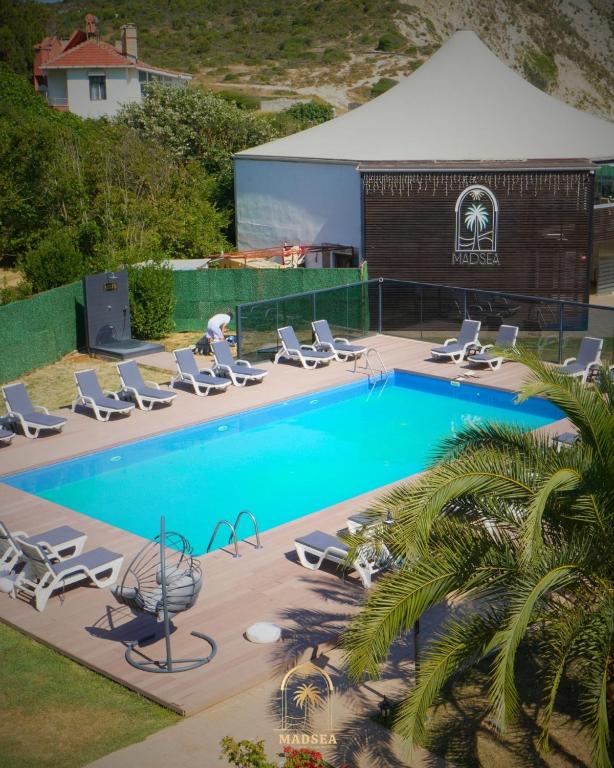 an overhead view of a swimming pool with chaise lounge chairs and a swimming pool at Mad Sea Beach Hotel in Şile