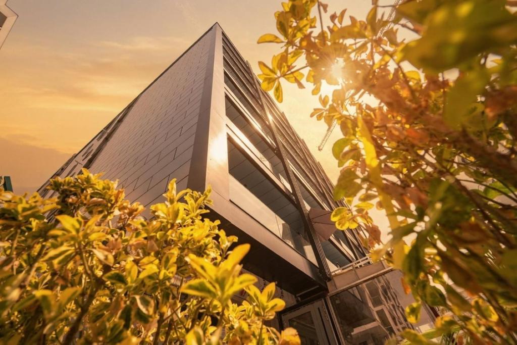 a tall building with the sun shining on it at Blue Boat Aparthotel in Mamaia Sat/Năvodari