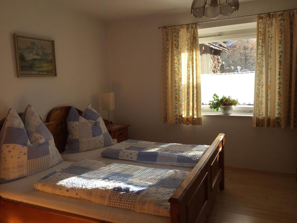 een slaapkamer met twee bedden en een raam bij Haus Stainer in Lofer