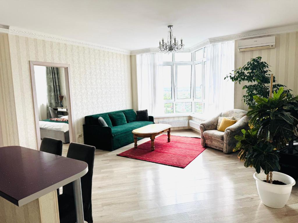 a living room with a green couch and a table at Apartments with Dnipro view in Kyiv