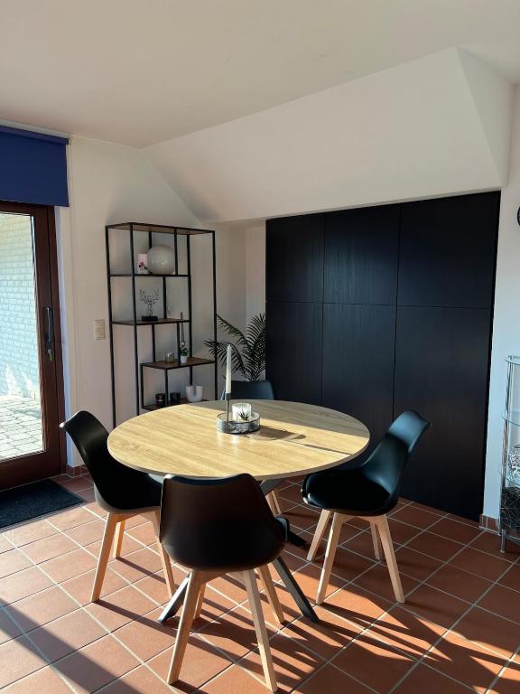 a dining room with a table and black chairs at Fernblick Oase in Meschede