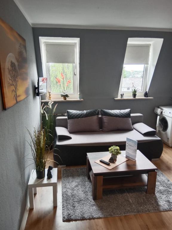 a living room with a couch and two windows at Katharinas Ankerplatz in Flensburg