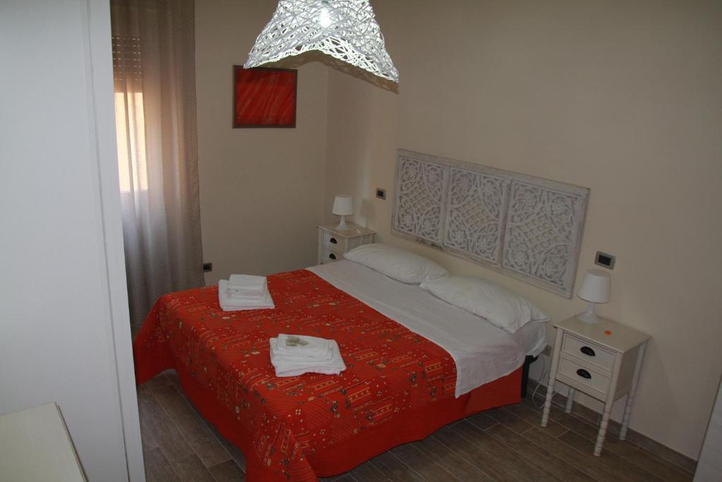 sypialnia z łóżkiem z czerwonym kocem w obiekcie Profumi di mare Resort w mieście La Spezia