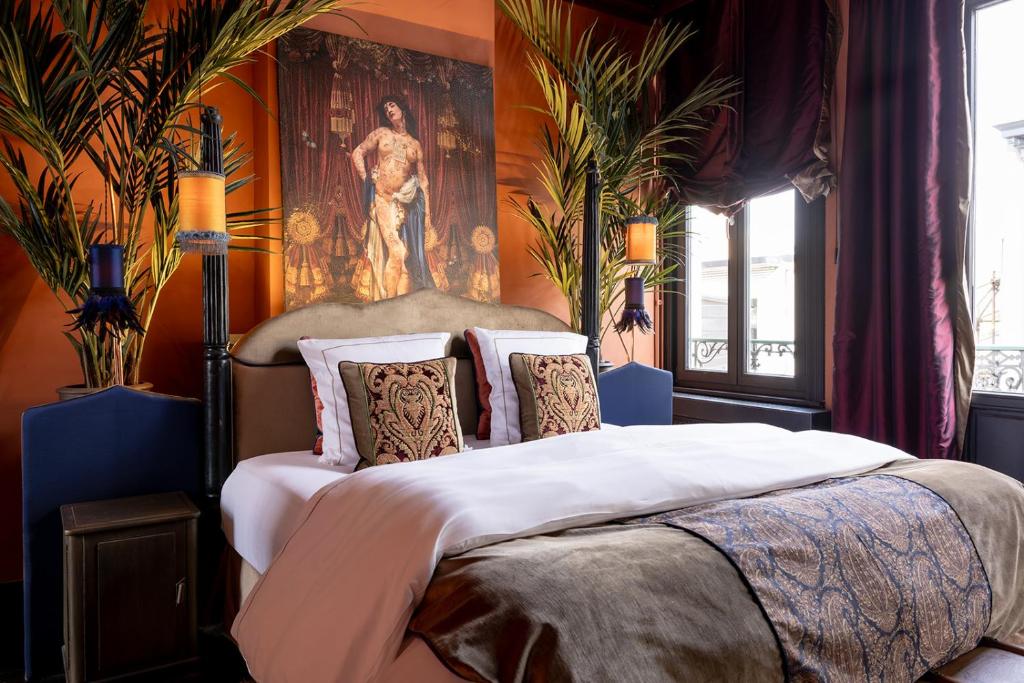 a bedroom with a large bed with a painting on the wall at Guesthouse Nights by Morpheus in Antwerp
