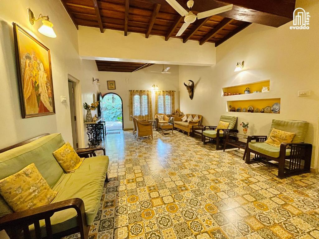 a living room with couches and chairs at The Thota Mane by evaddo stays in Sakleshpur
